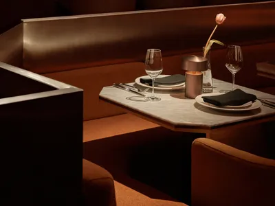 Marble table setting with dining chairs in a contemporary restaurant interior.
