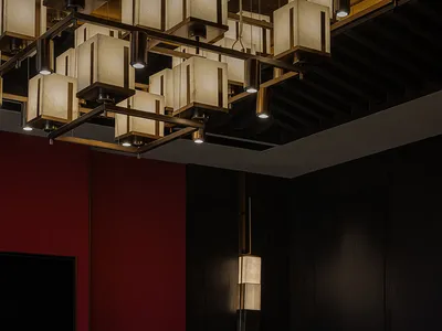 Modern, sleek restaurant dining area with circular table, contemporary lighting, and floral centerpiece.
