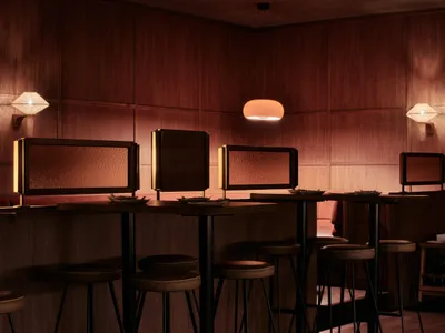 Modern restaurant bar with wooden accents and high stools.