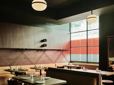 A modern restaurant interior featuring wood and leather elements.