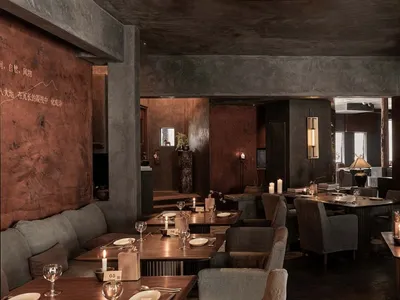 An industrial-themed restaurant with metallic walls, concrete floors, and loft-style design.