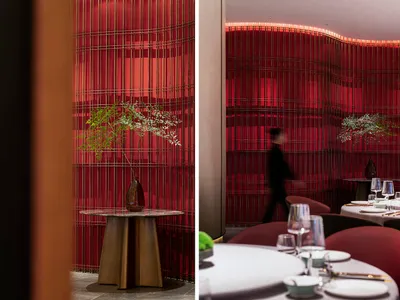 A modern restaurant interior featuring red acrylic walls and a curved design.