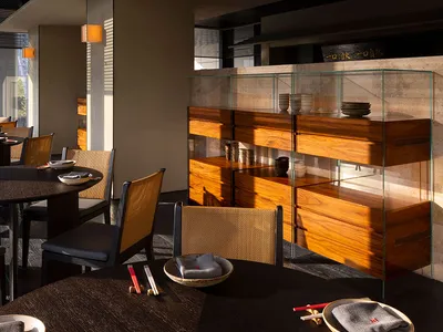 The interior of a modern restaurant featuring minimalist design in wood, glass, and wicker materials.