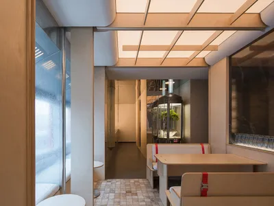Industrial-style restaurant interior with wooden materials and industrial design elements.