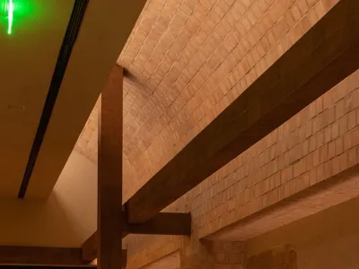 Modern restaurant interior with brick and concrete walls and wooden dining tables and chairs.
