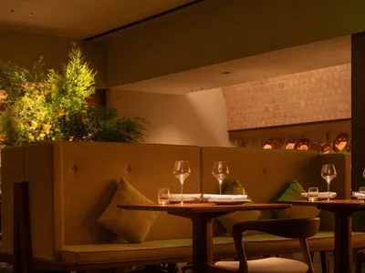 A cozy restaurant interior with wooden tables, cushioned seating, and a warm, inviting atmosphere.
