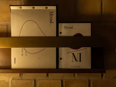 A modern restaurant menu board with a paper cover on a brick wall.