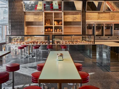 A modern French bakery with a sleek, contemporary interior featuring modern tiles, concrete, and glass.