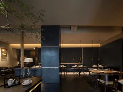 Modern restaurant interior with metallic finishes and concrete elements