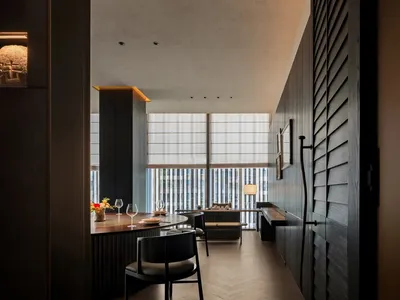簡約風格的餐廳室內，搭配木質餐桌、玻璃窗與金屬點綴。