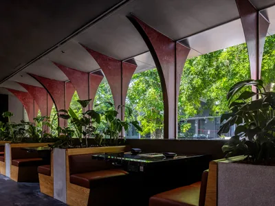 Industrial-style restaurant interior with wooden seating and ceiling