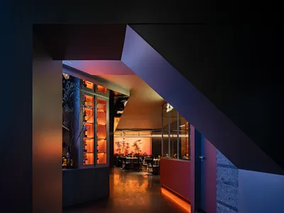 Modern restaurant interior with metal railings and leather seating.