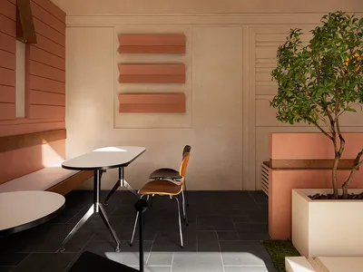 Modern restaurant interior with concrete and terrazzo finishes, featuring minimalist design elements and sleek lines.