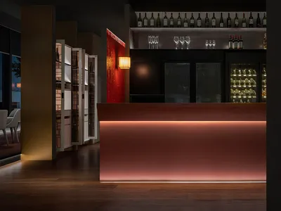 Interior of a modern restaurant or bar with metallic, glass, and wooden elements.