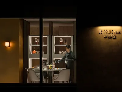 Modern, minimalist restaurant interior with sleek furniture, subdued lighting, and elegant table setting.