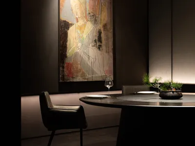 A modern restaurant dining room with a stone surface table and minimalist decor.