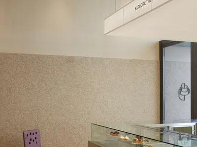 Modern bakery interior with a glass display case filled with pastries and a marble countertop.