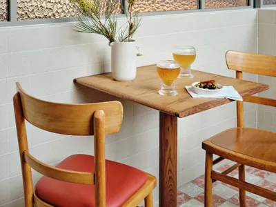 A modern restaurant setting featuring wooden furniture and glass dividers.