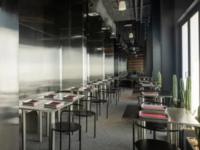 Modern, minimalist restaurant interior with metallic countertops and chairs.
