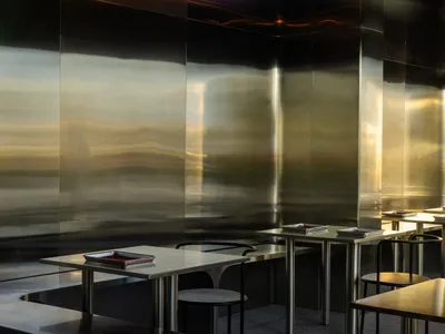 A modern restaurant kitchen with sleek, metallic counters and a minimalist aesthetic.