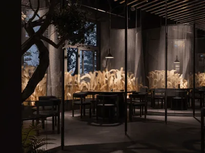 Industrial restaurant interior with metal furniture, glass partitions, and concrete floor.