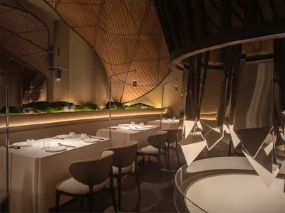 Industrially designed restaurant interior with metal, wood, and glass materials.