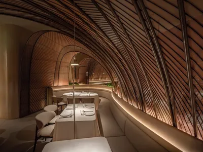A modern restaurant interior with curved wooden walls and a contemporary design.