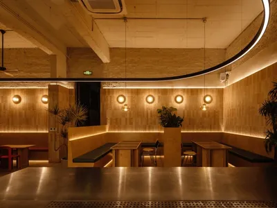 A cafe interior with wooden walls, seating areas, and decorative lighting fixtures.