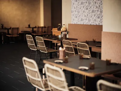 Industrial style restaurant interior with wooden tables and woven fiber chairs
