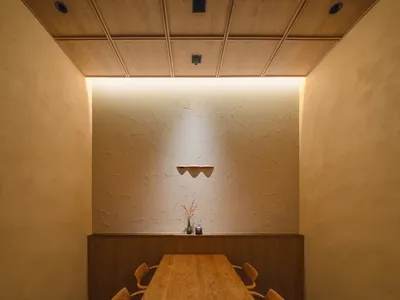 極簡風格的餐廳室內，擺放一張長形木桌與木椅。