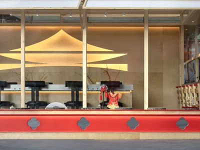 Modern restaurant interior featuring wooden walls and red accents