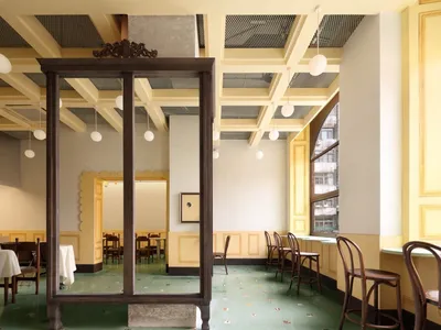 Interior of a modern restaurant featuring wood, concrete, and glass materials.