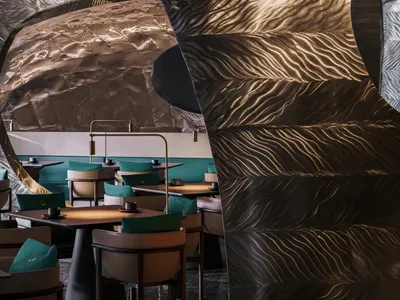 Restaurant interior with metallic textured walls and turquoise accents