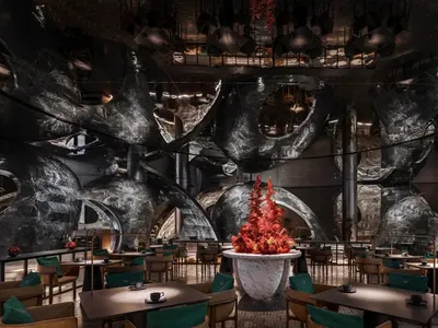 Industrial-style restaurant interior featuring metallic walls and furniture.