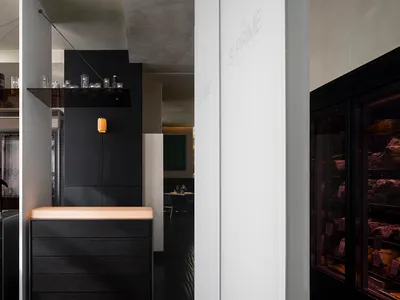 Modern restaurant interior featuring minimalist design with concrete and metal finishes.