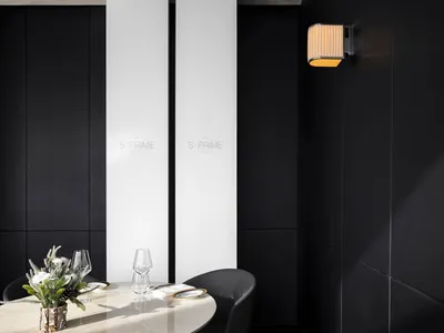 The image showcases a modern restaurant dining room with dark black walls, white accents, and a minimalist design aesthetic.