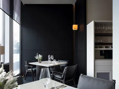 Modern minimalist restaurant interior with black and white color scheme, featuring contemporary furniture and sleek design el
