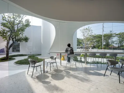 A modern restaurant bar with glass walls and white interior features.