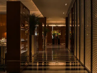 A modern restaurant hallway featuring wooden walls and black and white tiled floors.