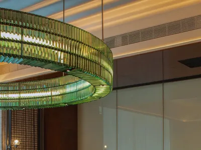 Modern restaurant interior with a large marble table and contemporary lighting fixtures.