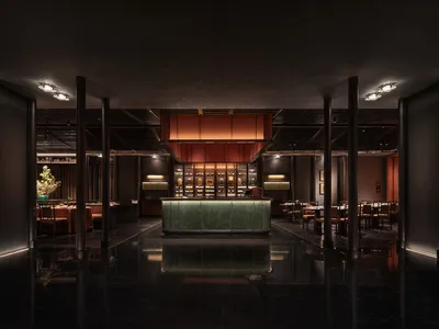 極簡餐廳內部，設有大理石吧台、木質餐桌與金屬椅。