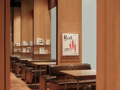 A detailed view of a modern restaurant dining room with cork floor, wood-paneled walls, and bookshelves filled with books.
