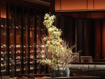 A modern restaurant interior featuring a vase of white flowers.
