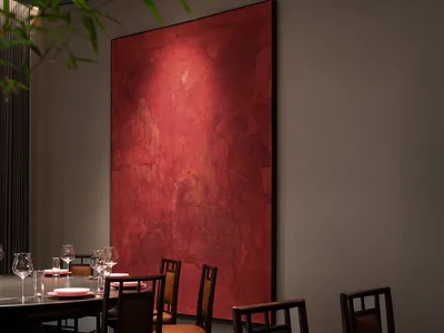 A modern restaurant interior featuring a large, striking red wall art.