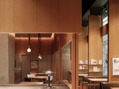A modern restaurant interior with wooden walls and reflections.