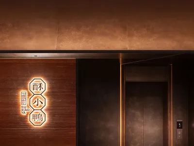 Modern restaurant entrance with metallic material and illuminated logo.