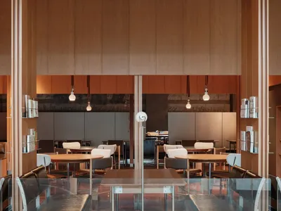 Modern restaurant interior with wooden tables, white chairs, and glass partitions.