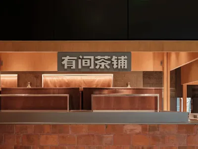 Modern restaurant interior featuring wooden paneling and metal counters.