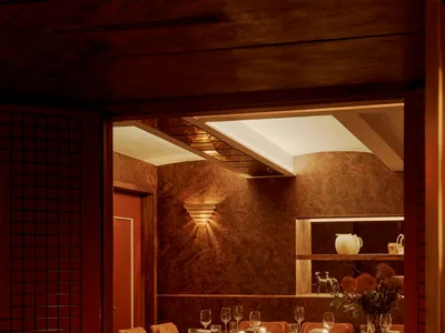A cozy, industrial-themed restaurant interior with metal accents, brick walls, and glass drinkware.