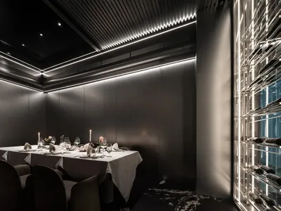 一間時尚現代的餐廳餐廳，擁有金屬質感牆面，搭配柔和LED燈光照明，並設有餐桌